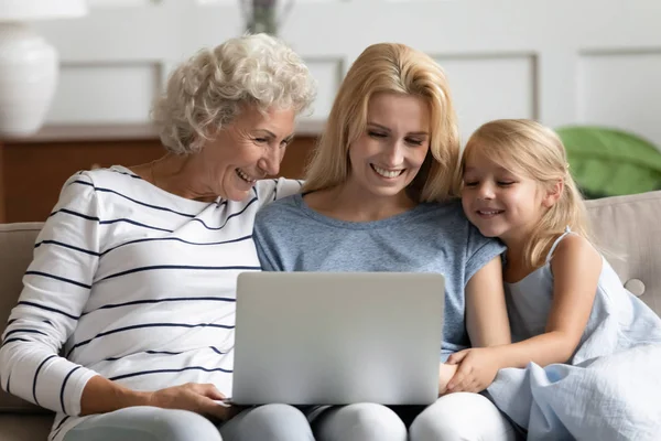 Happy three generation family looking at laptop screen . — Stok Foto