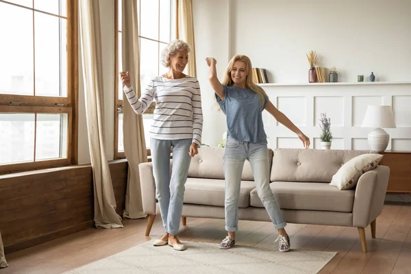 Overhappy middelbare leeftijd vrouw dansen met volwassen dochter. — Stockfoto