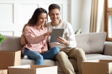 Gülümseyen milenyum çifti, taşınma gününde masayı kullanıyor.