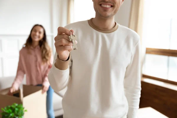 Überglücklicher junger Mann zeigt Hausschlüssel und zieht mit Frau um — Stockfoto