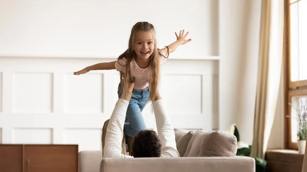 Overjoyed little girl playing with loving dad at home — Stock Photo, Image