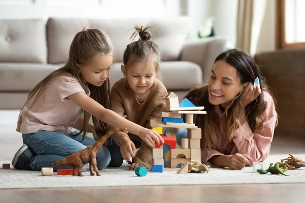 Joven mamá jugando con ladrillos de construcción con hijas pequeñas — Foto de Stock