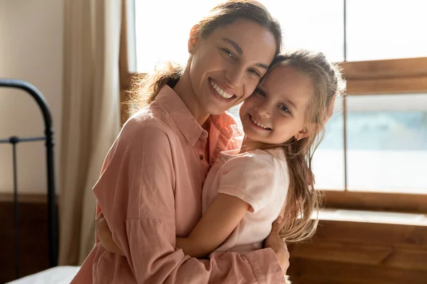 Portret van liefdevolle moeder en kleine dochter knuffelen — Stockfoto