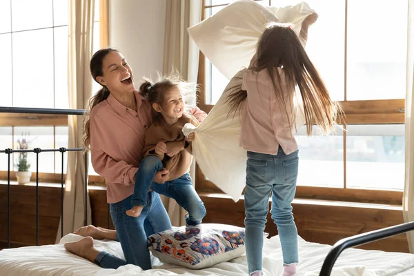 Overjoyed mamma giocare in camera da letto con le figlie piccole — Foto Stock