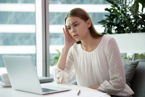 Gestresste junge Büroangestellte vor schwerer Aufgabe. — Stockfoto