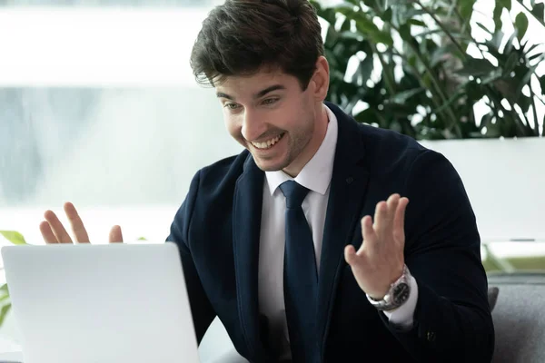 Opgewonden verrast jonge zakenman op zoek naar laptop scherm. — Stockfoto