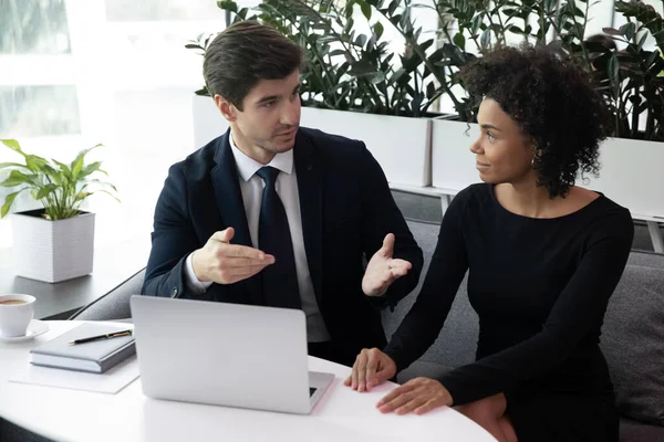 Fokussierter Geschäftsmann kommuniziert mit motivierter afrikanisch-amerikanischer Kollegin. — Stockfoto