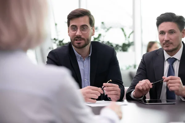 Focused manager in eyeglasses making offer to client at meeting. — Stock Photo, Image