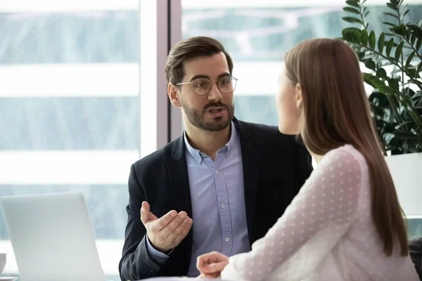 Focused male team leader mentoring young female intern at office. — Stock Photo, Image
