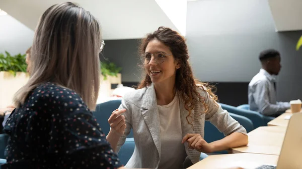 Millennial female employees talk sharing ideas at workplace — Stock Photo, Image