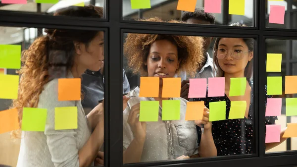 Colleghi multietnici concentrati brainstorming utilizzando note appiccicose — Foto Stock