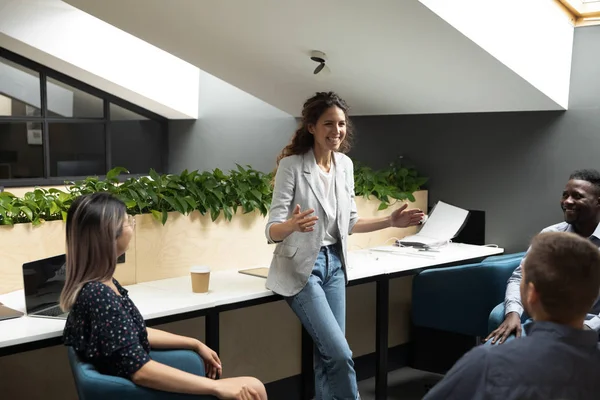 Smiling female leader hold team meeting in coworking space — Stock Photo, Image