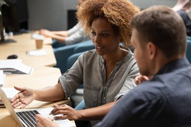 Ortak ofiste erkek meslektaşla işbirliği yapan etnik kadın çalışanlar.