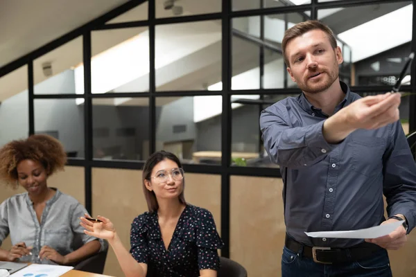 Kaukasiska manliga högtalare gör ombord presentation för lyssnare vid genomgång — Stockfoto