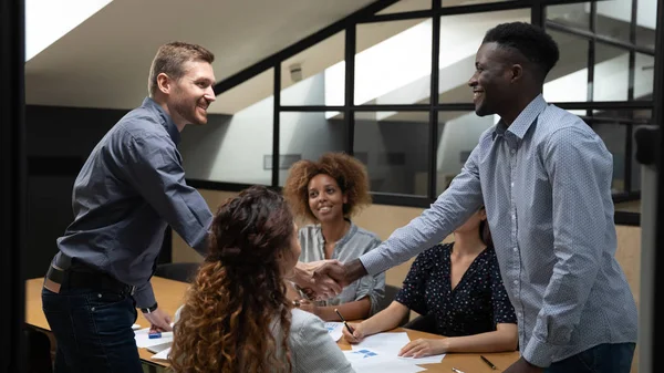 Multiethnic male colleagues handshake greeting at briefing — Stock Photo, Image