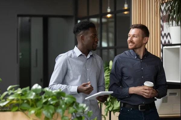 Multiethnic male colleagues stand talking discussing ideas — Stock Photo, Image