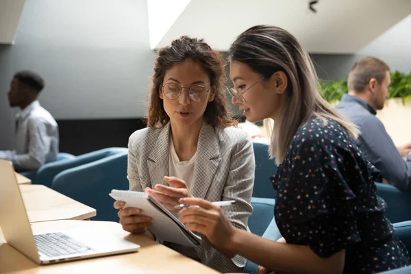 Focused millennial women discuss business plan in office — ストック写真