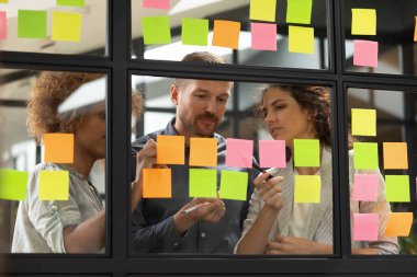 Çıkartmalarıyla ilgili fikirler yazmakla meşgul çok ırklı meslektaşlar.