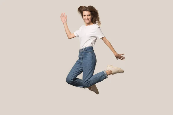 Aktiv ung kvinna hoppar högt poserar i studion — Stockfoto