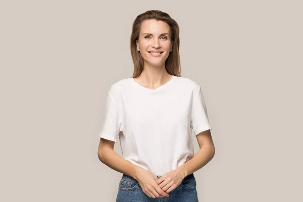 Portrait of smiling millennial woman posing for picture in studio — Stock Photo, Image