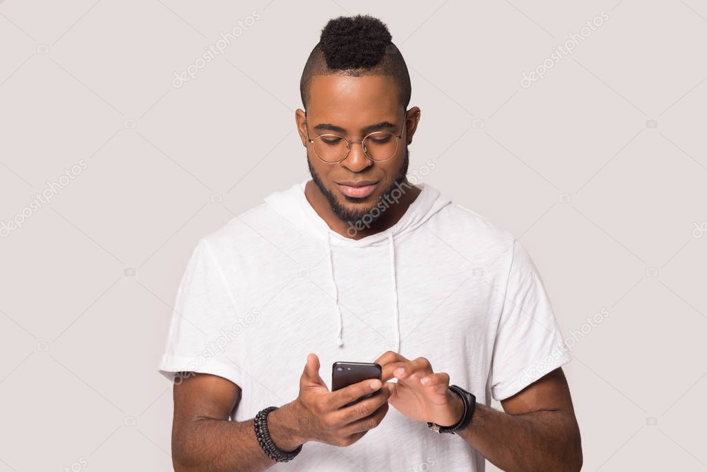 African American man stand using smartphone in studio