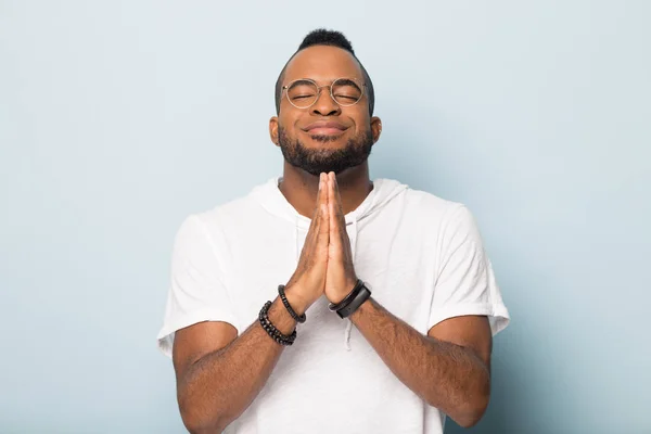 Hopplös svart man håller hand i bön hopp om lycka — Stockfoto