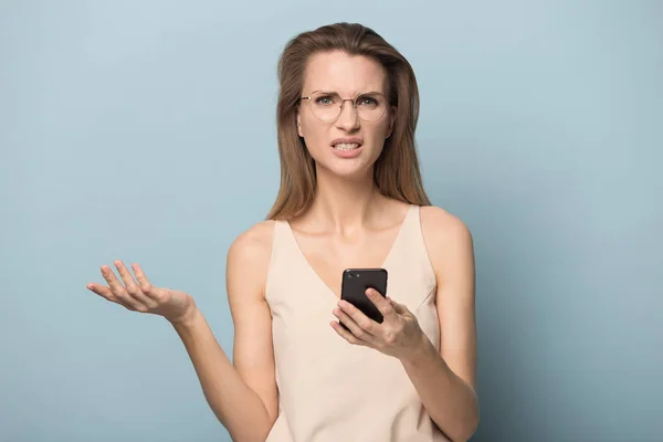 Mulher confusa em óculos segurar celular com problemas de conexão — Fotografia de Stock