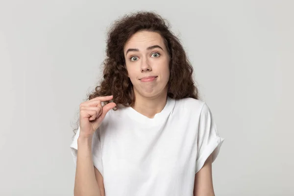 Primer plano joven mujer decepcionada mostrando pequeño tamaño de medición . —  Fotos de Stock