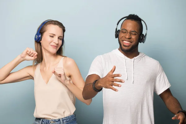 Homem e mulher multirracial feliz desfrutar de música em fones de ouvido — Fotografia de Stock
