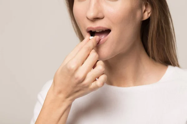 Close up of young woman taking pill — Stock Photo, Image