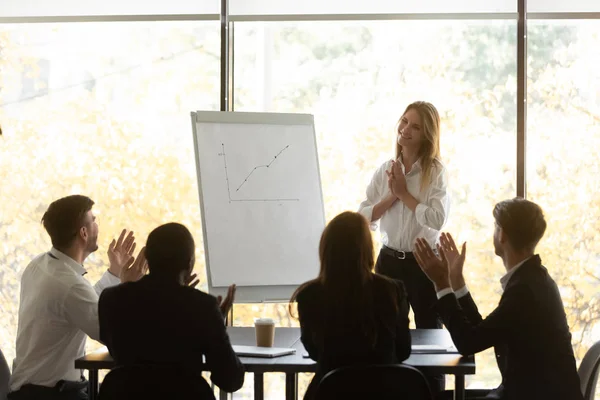 Employees applauding to woman speaker for successful flipchart presentation — Stock Photo, Image