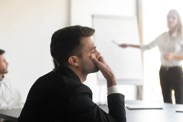 Uttråkad anställd somnar under seminarium eller presentation på kontoret — Stockfoto