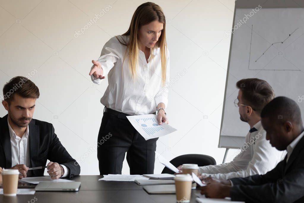 Female boss and employee having conflict during meeting in boardroom