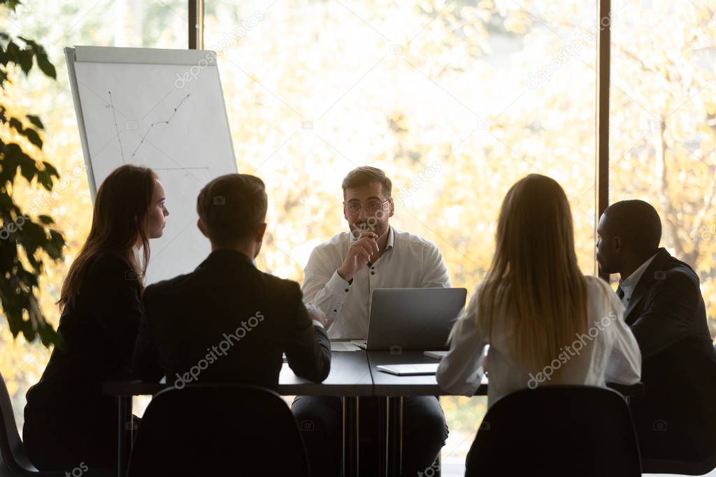 Confident businessman makes presentation for investors during group meeting