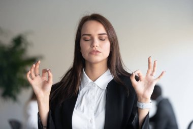 İş kadını meditasyon yaparken derin nefes almak stresi ve endişeyi azaltır.