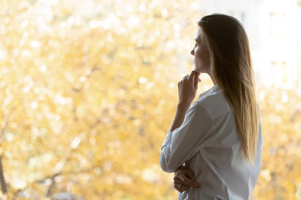 Pensive businesswoman standing in office looking out window search solution — Stock Photo, Image