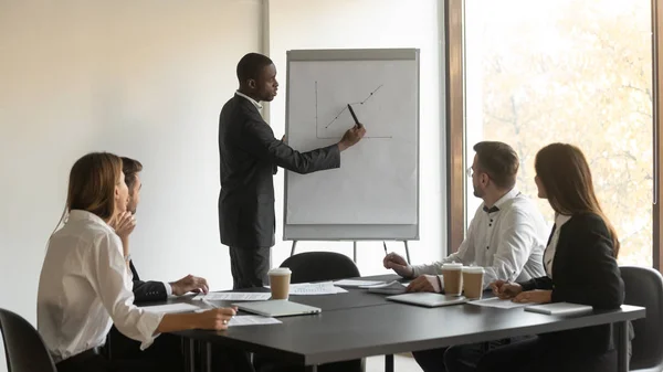 African coach makes presentation for staff sales results on flipchart — Stock Photo, Image
