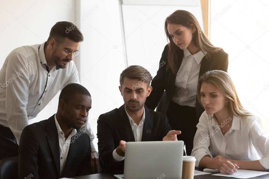 Corporate staff discuss new business application with colleagues using computer