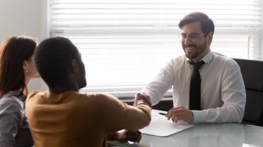 Finansal danışman el sıkışıyor, tebrik ediyor veya çok ırklı aileyi selamlıyor