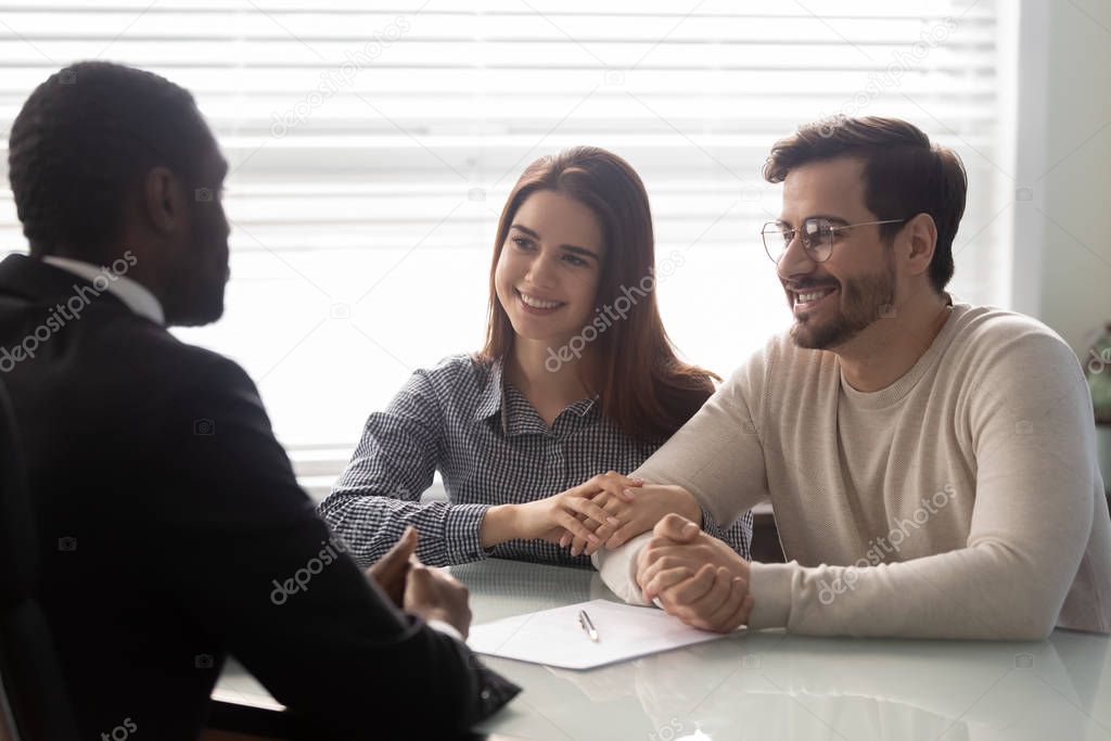 Couple and insurance agent communicating sitting at desk