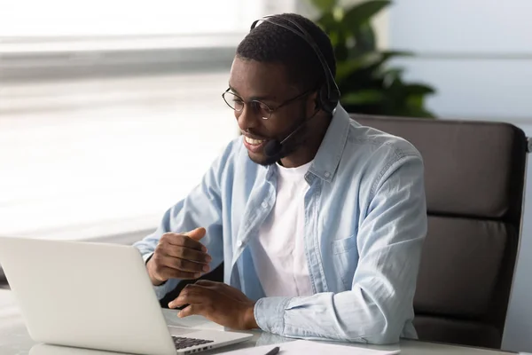 Telemarketer africano usando headset responde chamadas recebidas vender produtos — Fotografia de Stock