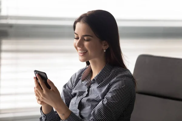 Mujer sosteniendo teléfono inteligente se siente feliz recibido buenas noticias —  Fotos de Stock