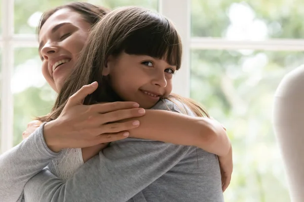 Happy little girl and young mom hugging — Stock Photo, Image