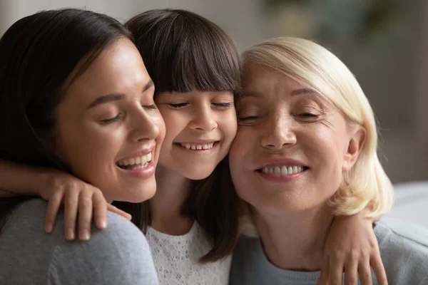 Smiling three generations of women hug and cuddle — Stock Photo, Image