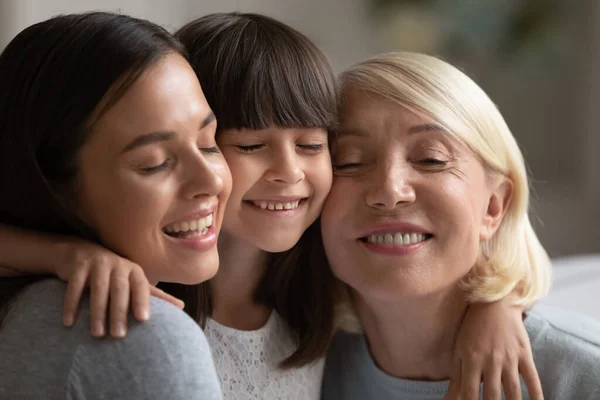 Sonriendo tres generaciones de mujeres abrazándose y abrazándose —  Fotos de Stock