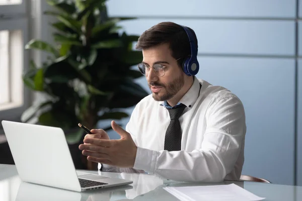 Empresário em fones de ouvido faz videocall conversando com cliente de consultoria parceiro — Fotografia de Stock