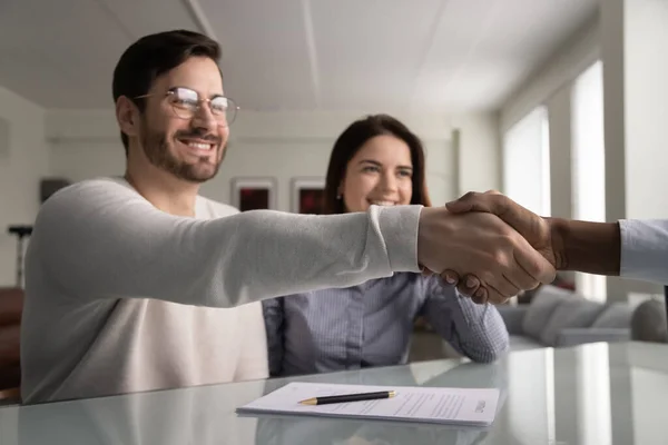 Smiling satisfied millennial man shake hands with insurance agent — Stock Photo, Image