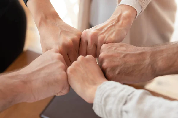 Close-up van diverse medewerkers sluiten zich aan bij vuisten die zich bezighouden met teambuilding — Stockfoto