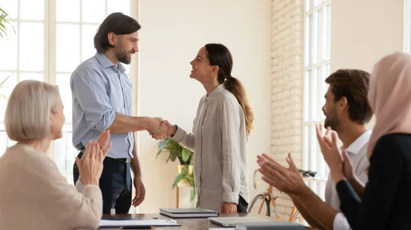 Sonriente hombre de negocios apretón de manos saludo empleado femenino con promoción — Foto de Stock