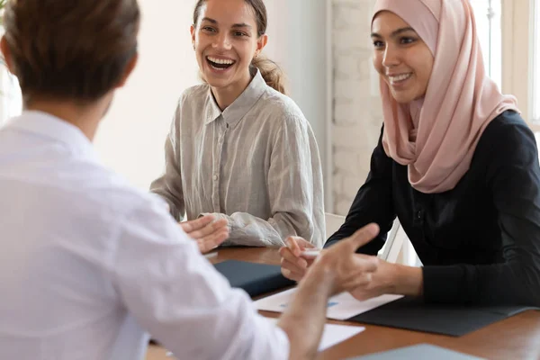 Felices empleados multirraciales se ríen discutiendo ideas en reunión —  Fotos de Stock